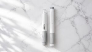 Two GLP-1 injection pens side by side representing the Mounjaro vs Wegovy comparison